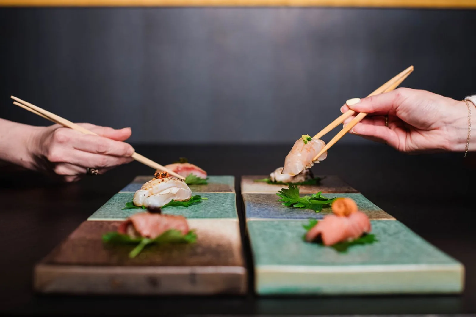 Nigiri served on ceramic tiles at the omakase counter