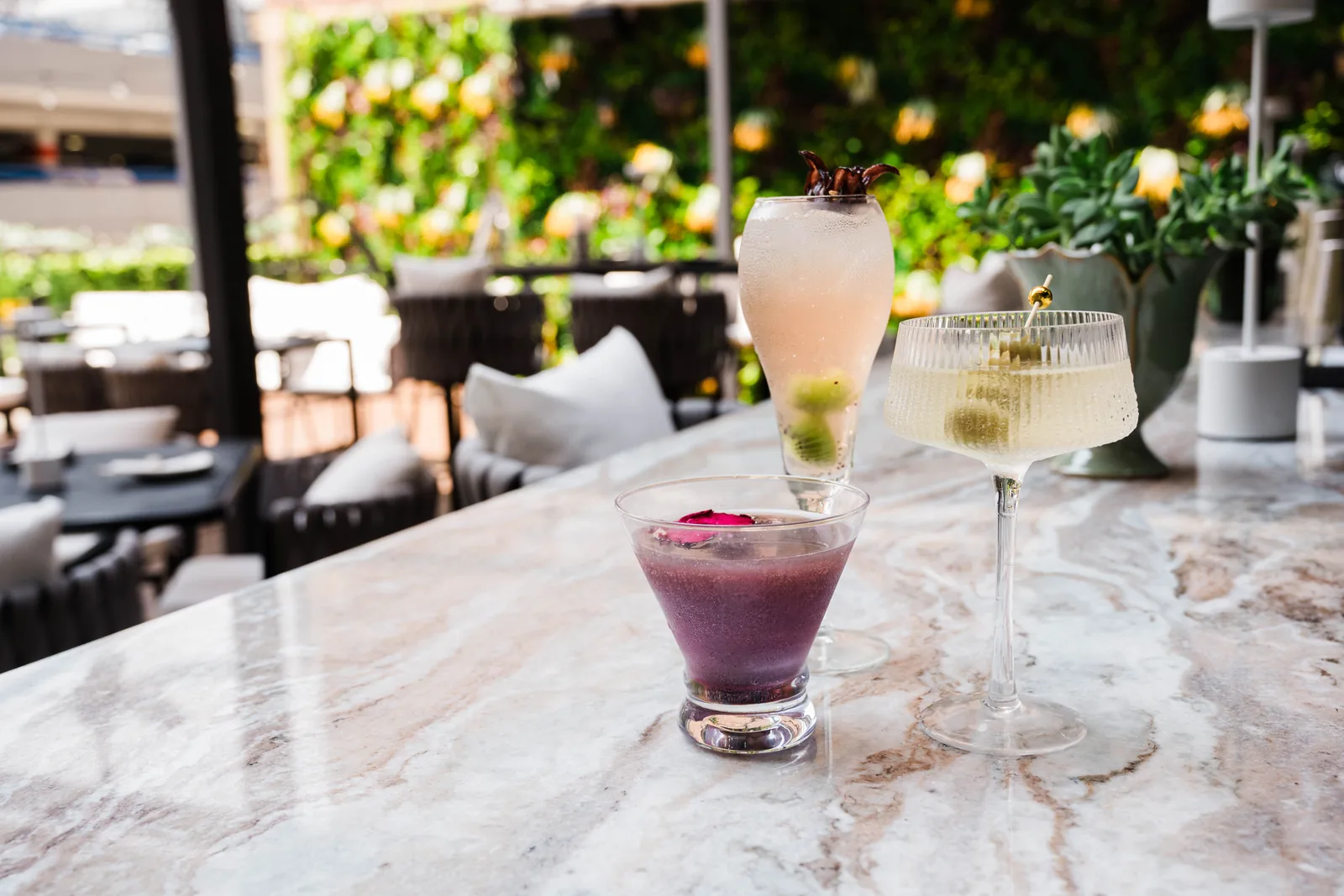 Three cocktails lined up on the marble bar