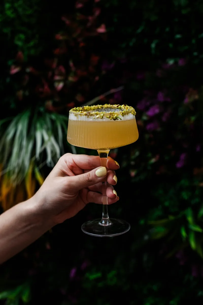 A golden coupe raised against the rooftop greenery