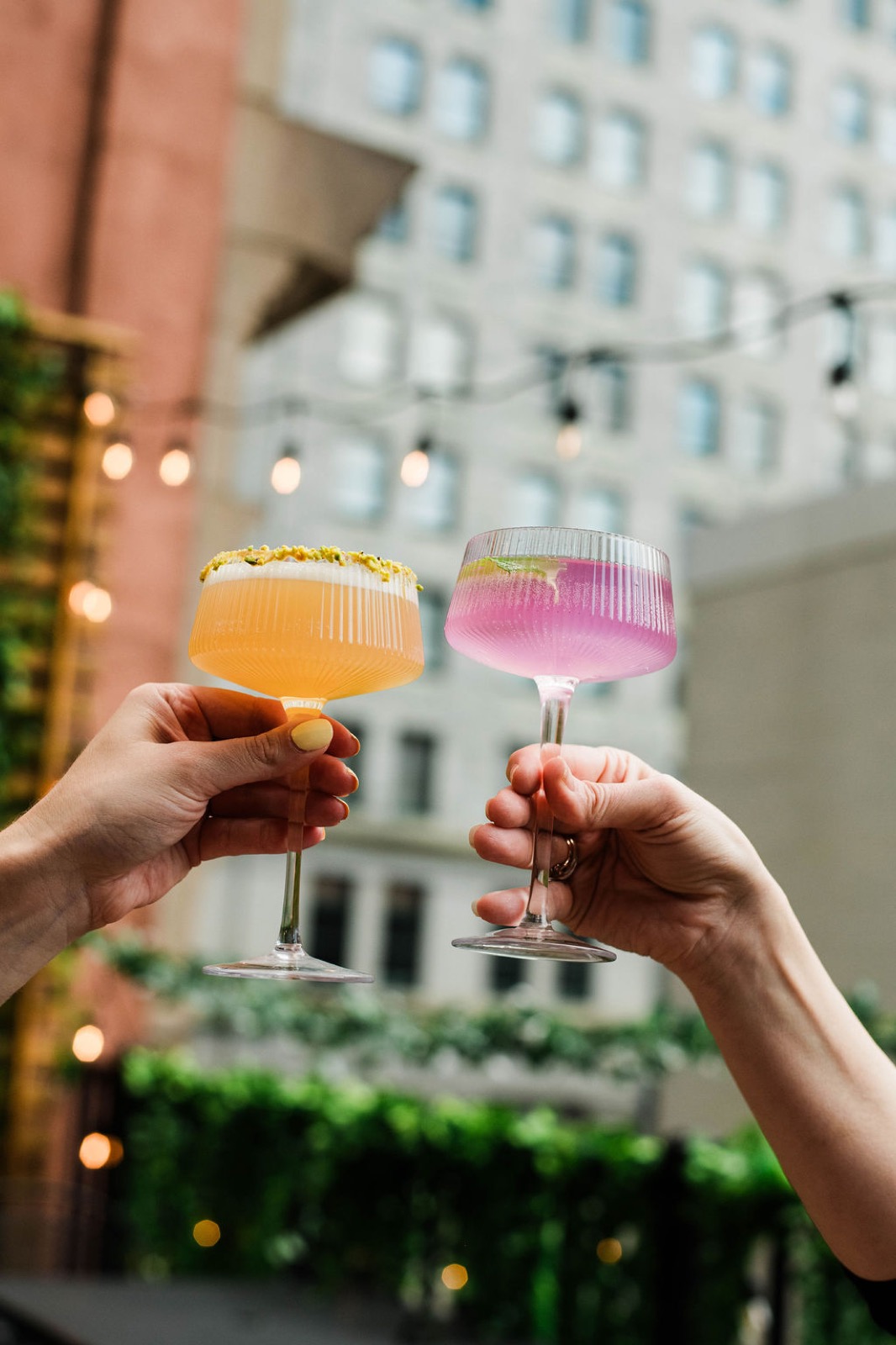 A cocktail cheers on the rooftop above downtown Pittsburgh