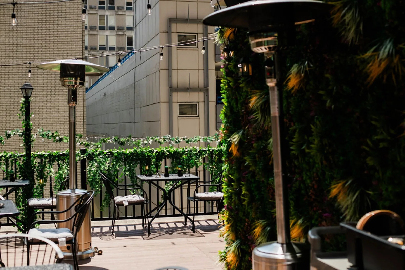 The Okane Rooftop patio with string lights and greenery